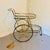 Elegant vintage Hollywood Regency brass and glass bar cart featuring a wonderful two-tier design with rounded fronts,...