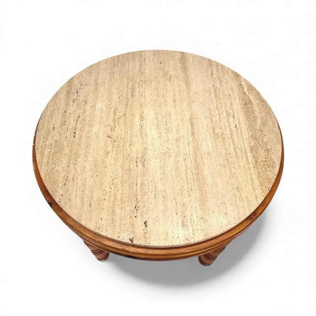 A handsome two tiered round center table by Baker Milling Road featuring turned wood legs and a tan travertine top.