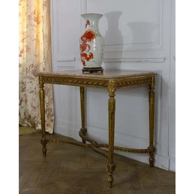 Beautiful Louis XVI style center table or console in gilded wood marble top. It is sculpted as a belt with a ribbon frieze...