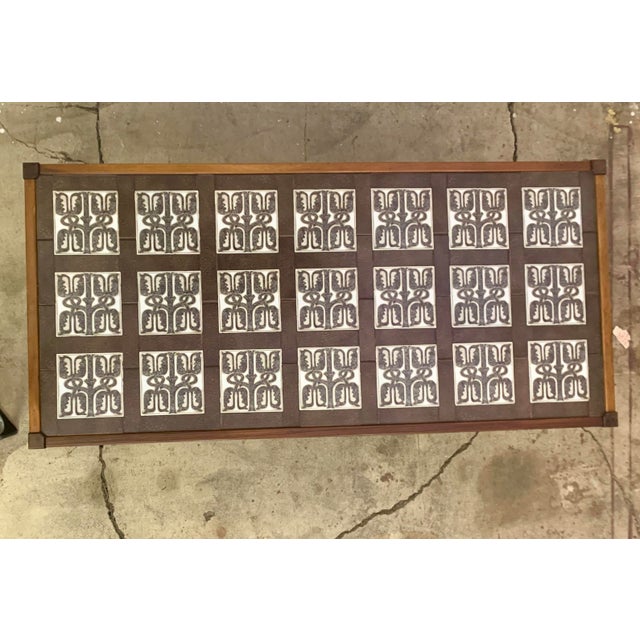 A rare, collectible Danish coffee table made in the 1960s, featuring an exquisite palisander (rosewood) veneer frame and a...