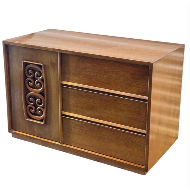 Mid-century walnut bachelor’s chest with mixed storage. Walnut veneer case with warm tone. One door with carved decorative...