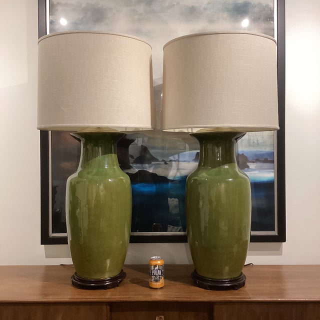 A commanding and beautifully scaled pair of monumental ceramic table lamps in a rich olive green glaze, now paired with...