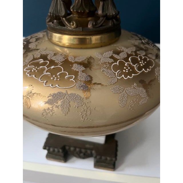 An exceptional and monumental pair of Hollywood Regency table lamps, masterfully combining hand-painted glass, sculptural...