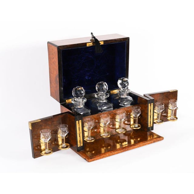 This is a fine antique Victorian burr walnut three-decanter tantalus, circa 1880 in date. The stunning burr walnut fold-...