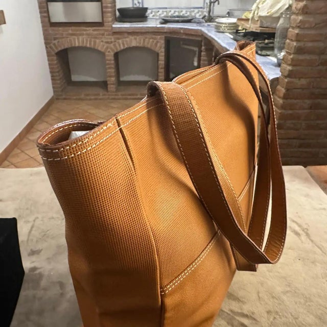 This is a 1990s brown leather tote bag by Fendissime, a diffusion line by the luxury brand Fendi. The bag features a soft...
