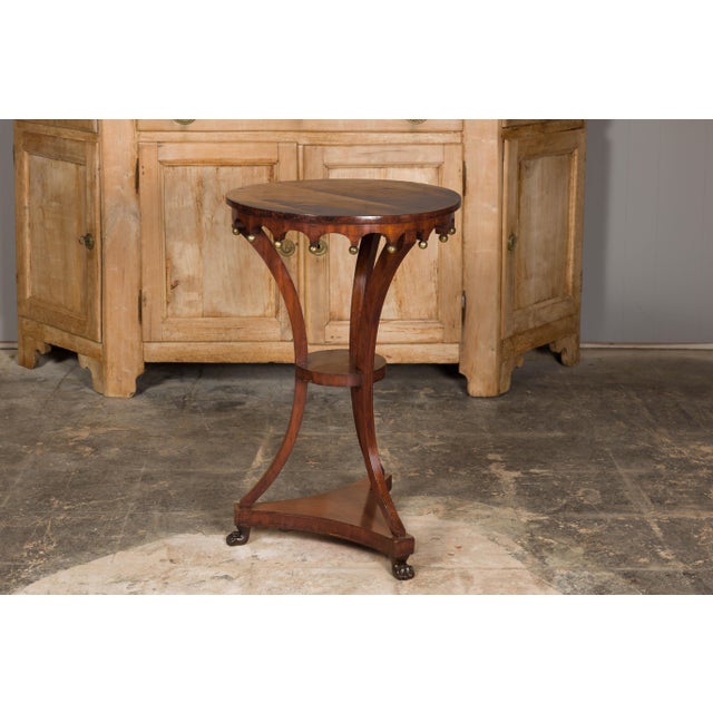 An Italian walnut guéridon side table from the early 19th century with parquetry top, carved apron, petite gilt spheres...