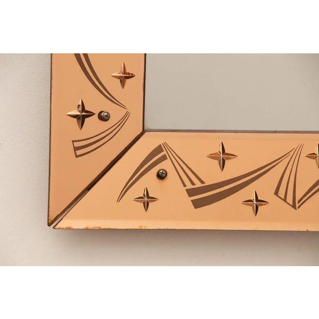 H: 59cm w: 80cm d: 4.5cm a french art deco mirror with a bevelled champagne border featuring shooting star design. The...