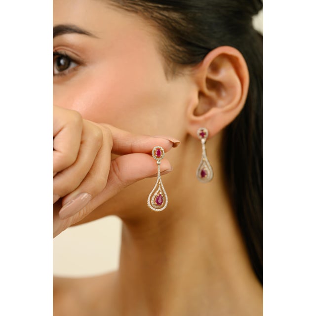 These elegant dangle drop earrings features 4 oval & pear cut rubies 1.4 carats, set in 18k yellow gold. Rubies measures...