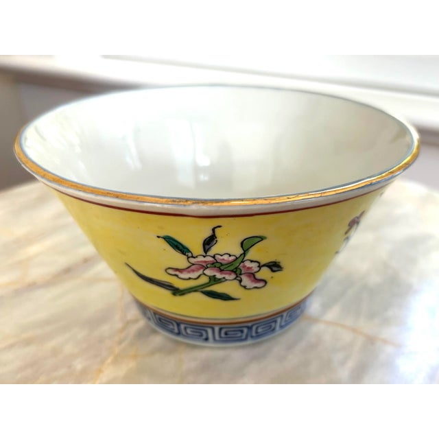 A beautiful, vivid yellow, vintage Chinese porcelain bowl. Hand painted cherry blossoms and flowers adorn this eye-...