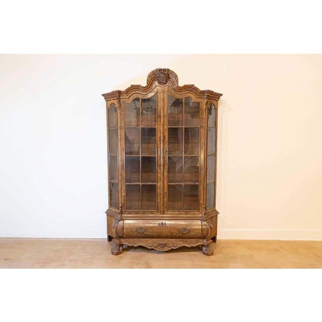 A Dutch walnut Rococo Revival bombé vitrine from the late 19th century, with glass doors and single drawer. Created in the...