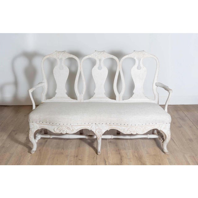 This Swedish 18th-century Rococo sofa, circa 1760, epitomizes the elegance and artistry of the Rococo period. Crafted from...