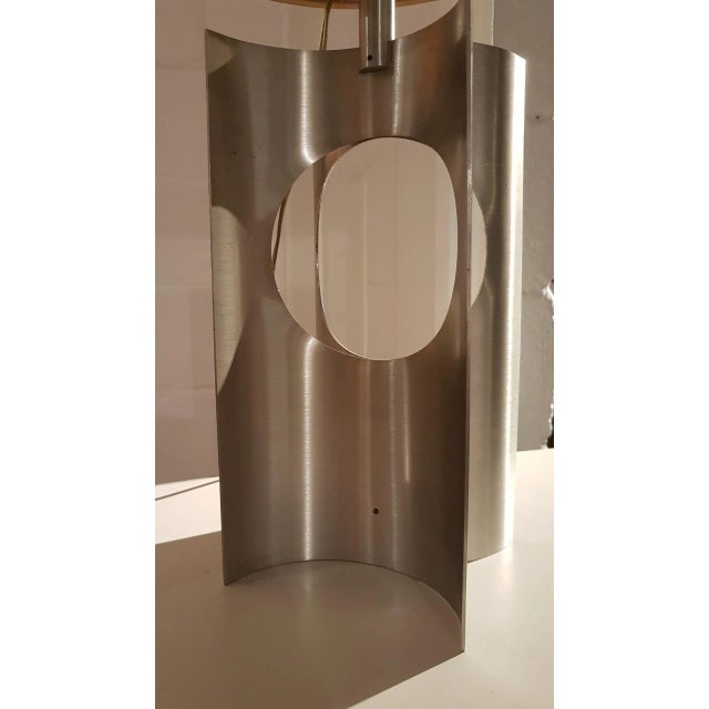 This table lamp in brushed aluminum features its original shade in brushed metal. It was produced in France in the 1970s....