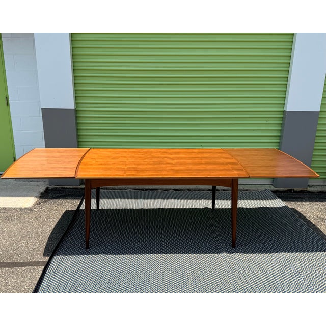 A refined Danish modern extension dining table produced by Gudme Møbelfabrik in the 1970s, crafted in warm teak with...