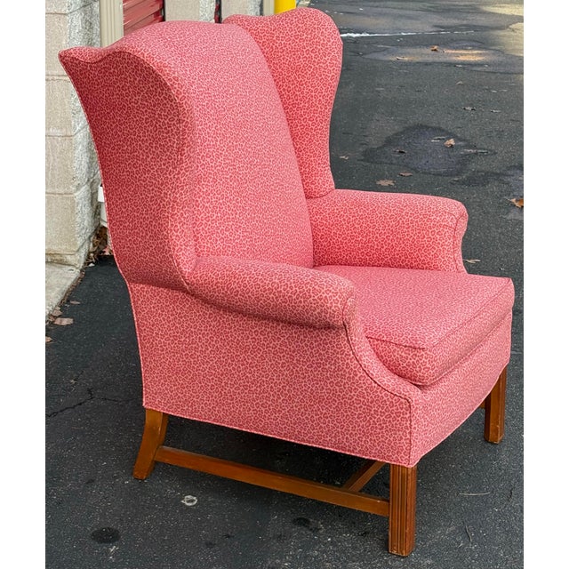 Generously proportioned wingback chair features a pink leopard upholstery, block legs, rolled arms and loose seat cushion....