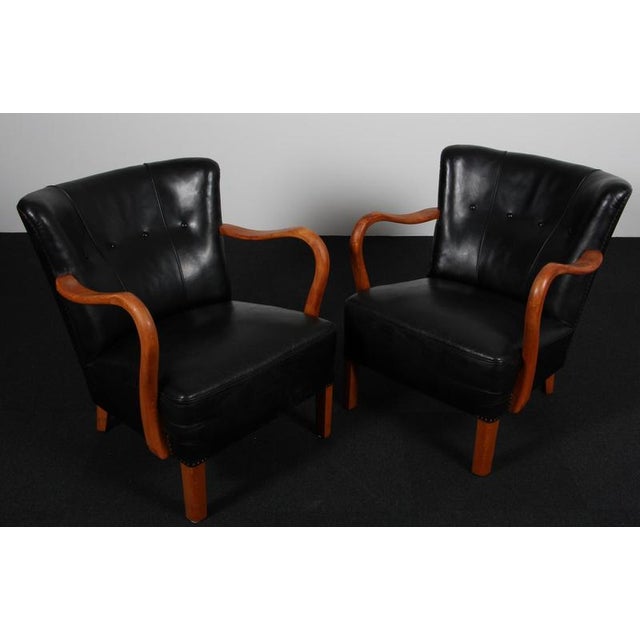 Alfred Christensen set of lounge chairs new original upholstered with black leather. Armrest and legs of stained beech....