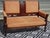 Two-seater bench in wood and fabric. Solid beech frame with numerous carved relief motifs on the legs and in the center of...