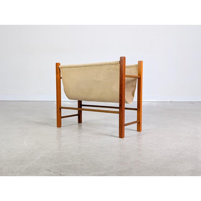 We are offering a beautiful vintage teak and linen magazine rack from the 1960s for sale. This piece of furniture...