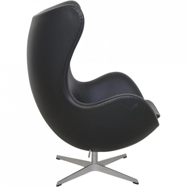 Arne Jacobsen Egg chair upholstered in original black Aura leather, and with a base of brushed aluminium. The chair is...