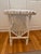 Adorable white painted wicker side table with magazine rack storage underneath. Significant chipping commensurate with use...