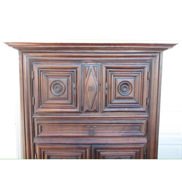 18th century French walnut paneled armoire from Normandy, carved and dated 1718 on the central panel. A well proportioned...