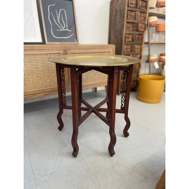 Antique Style Table with intricate Markings on the Top.Base has Wood Carved Features and Unit Legs.Top is Detachable....