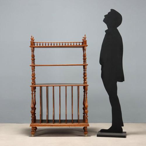 Walnut etagere. Two upper shelves supported by turned columns culminating in pendentives and a balustrade, a lower...