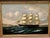 Simply stunning oil painting of a three-masted clipper ship unfurling sails into the wind in an ornate gilded frame....