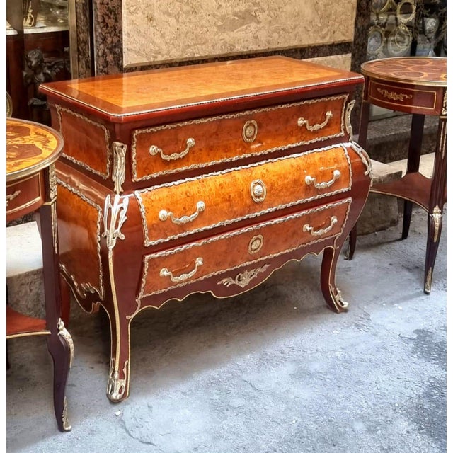 Make a statement with this magnificent French commode, showcasing exceptional floral marquetry, graceful serpentine lines....