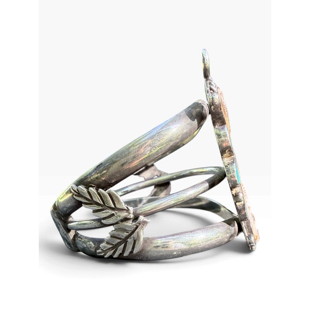 A bold vintage Navajo sterling silver cuff centered with a large butterfly motif set with natural turquoise and richly...