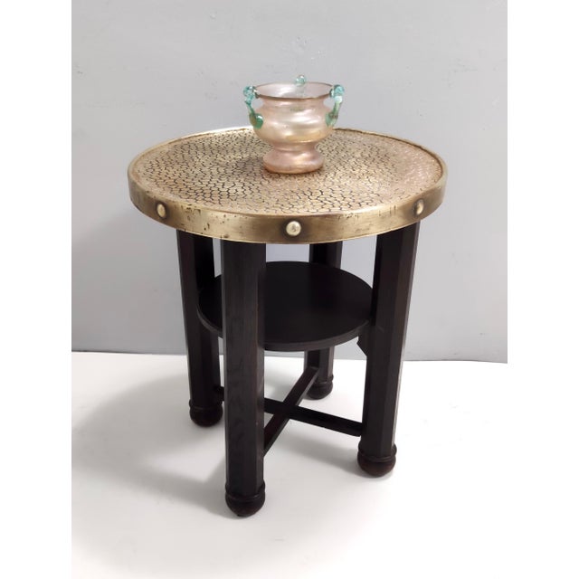 Made in Austria, 1920s. This coffee table features a durmast frame with a brass top and a shelf. This is a vintage piece,...