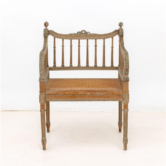 Louis XVI Style Cane Paneled Seat Fauteuil, the distressed carved wood frame with bow cresting and fluted legs. 32.5" H x...