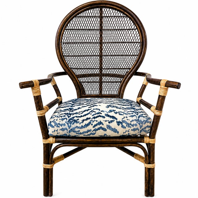 Elegant vintage rattan peacock armchair featuring a sculptural rounded fan back, woven cane detailing, and rich dark-...