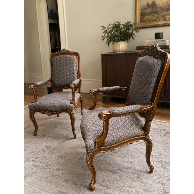 Set of two armchairs by Asnaghi Interiors, crafted in a Baroque Rococo style. The armchairs have ornate carved wooden...