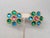1992 goldtone center cabochon pink rhinestone surrounded by cabochon green and aqua blue rhinestones in the shape of a...
