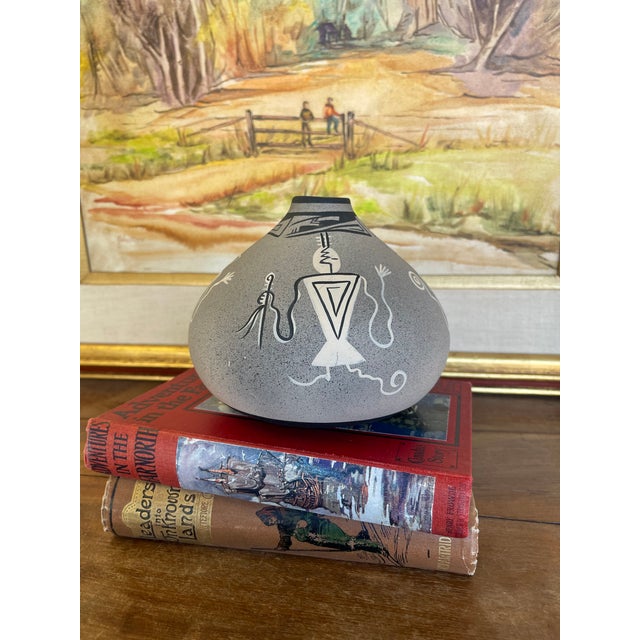 Vintage pottery vase featuring a rounded, squat form with a narrow neck and matte textured surface. The vessel is...