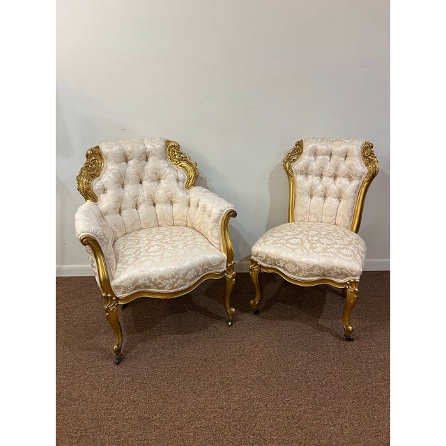 Carved solid wood gilded gold chairs with custom creme baroque upholstery. Side arm chair has one small piece of wood...