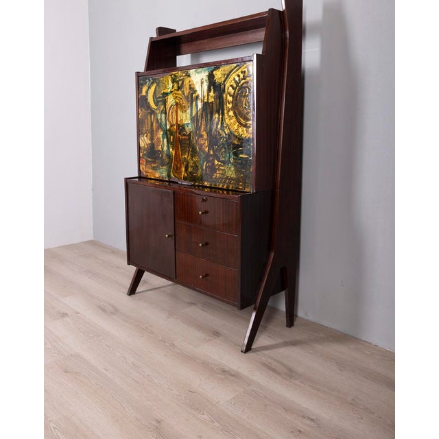 Tall lacquered wood sideboard, lower section with one door and three drawers, upper section with a decorated panel, drop-...