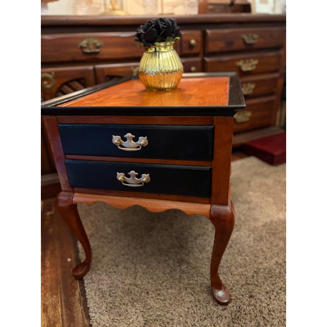 This furniture piece is a classic Queen Anne style end table (or nightstand) that features traditional cabriole legs, a...