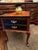 This furniture piece is a classic Queen Anne style end table (or nightstand) that features traditional cabriole legs, a...