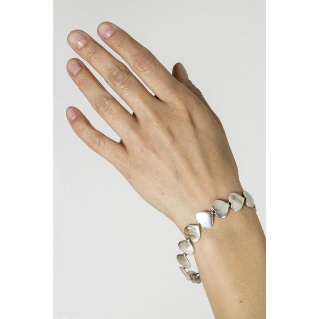Amazing silver bracelet by Karl Gustav Hansen, with heart-shaped links. Sophisticated sweetness with a neat screw lock,...