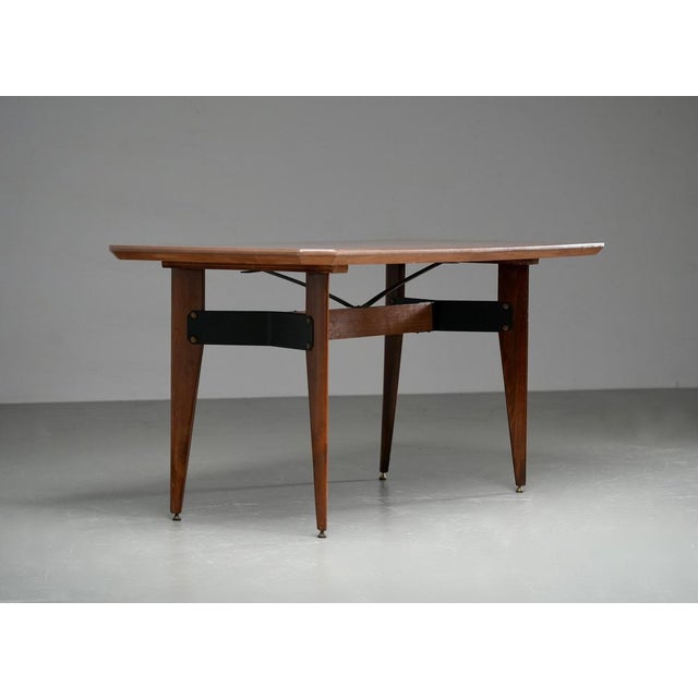 Smaller dining-room table with typical graceful Italian shapes. The table has somewhat flat and tapered legs and a...