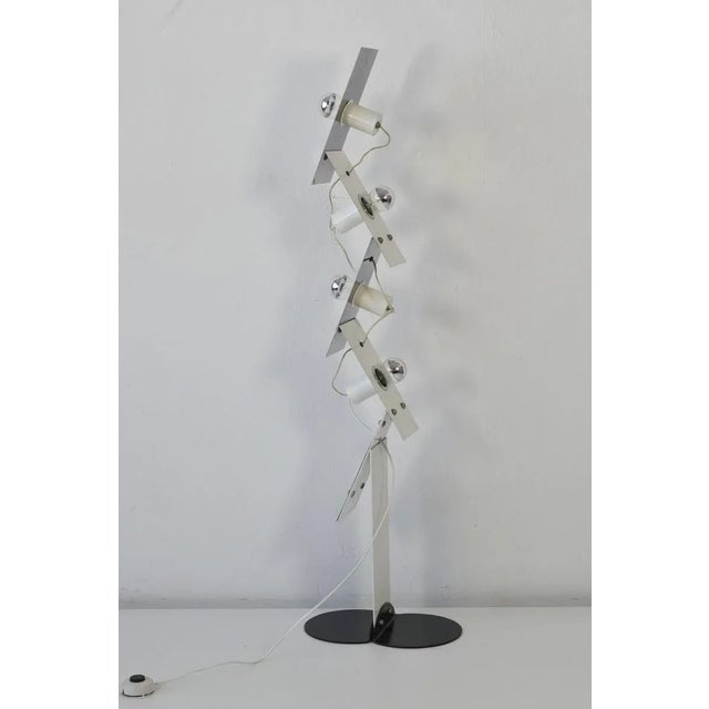 This floor lamp was produced around 1965. The piece features reflective surfaces that contrast the matt-lacquered white...