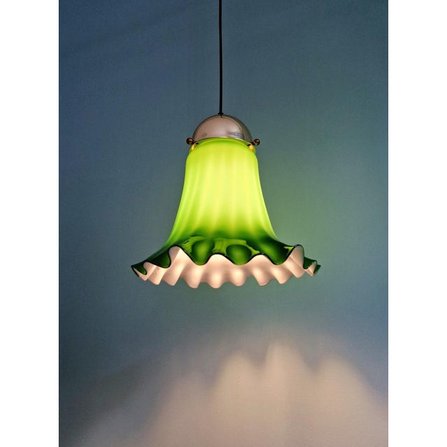 Green opaline glass and brass pendant light, produced by the german manufacturer peill & putzler, 1970s. the pendant has...