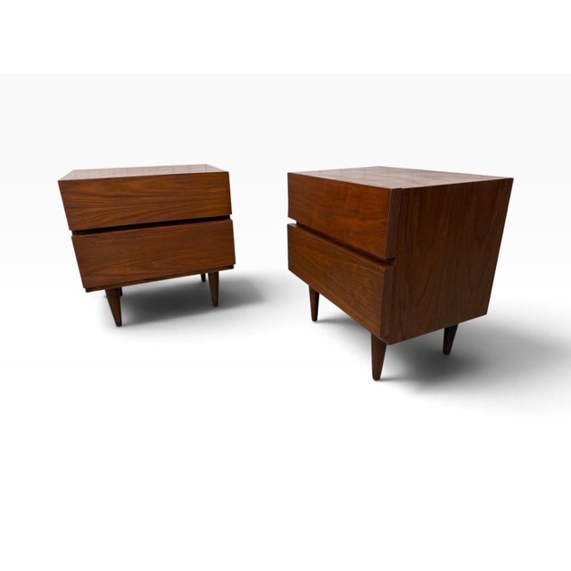 A striking pair of Mid-Century Modern walnut nightstands by American of Martinsville, dating to the 1960s. Expertly...