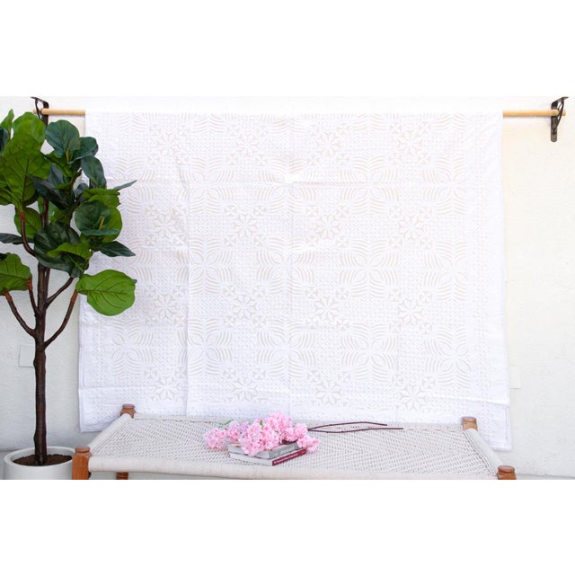 A lightweight cotton coverlet from Western India, beautifully adorned with intricate handcrafted appliqué cutwork. The...