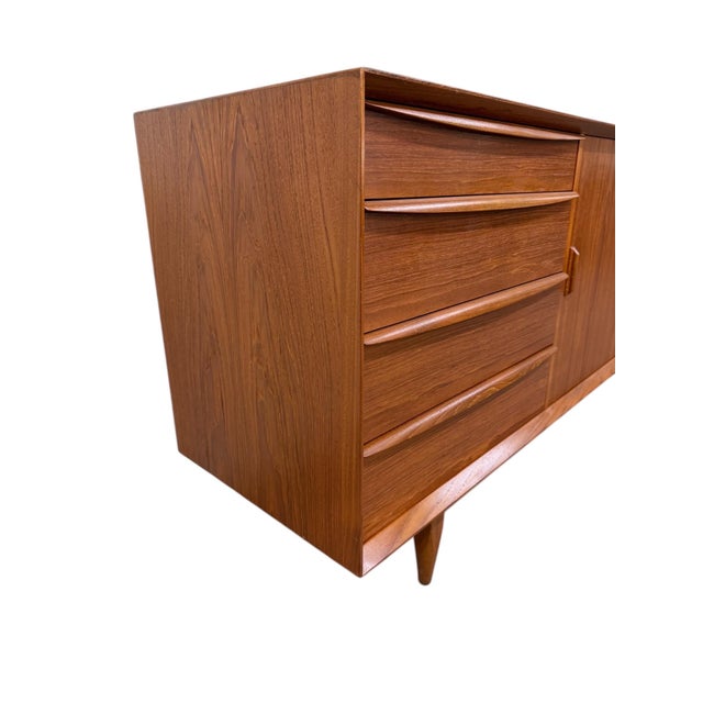 Elevate your space with this striking Danish Modern teak dresser, circa 1970s, showcasing clean lines and timeless...