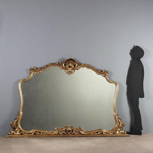 Large Rococo-style freestanding mirror in carved and gilded wood. The molded frame is enriched with scrolls, curls,...