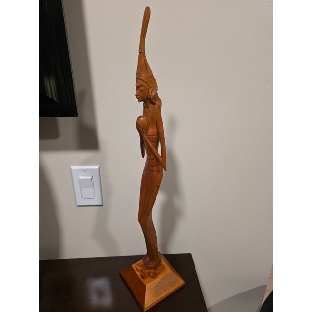 An extraordinary, gallery-grade mid-century Balinese modernist sculpture depicting an elegant elongated maiden. Standing...