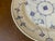 Hand painted delicate blue stylized floral motifs and fine lines radiating from the center; subtle ribbed texture