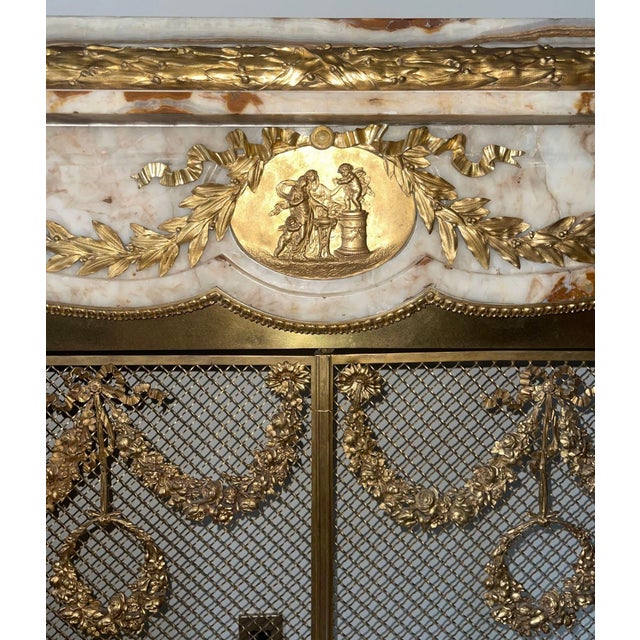 An exceptional 19th century French Louis XV–style fireplace mantle, exquisitely crafted in richly veined white and honey...